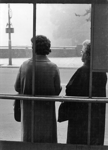 361166 Afbeelding van twee dames die wachten in de abri van een bushalte te Utrecht.